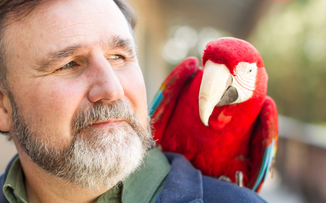 Dr. Waldsmith with Judy the macaw on his shoulder.