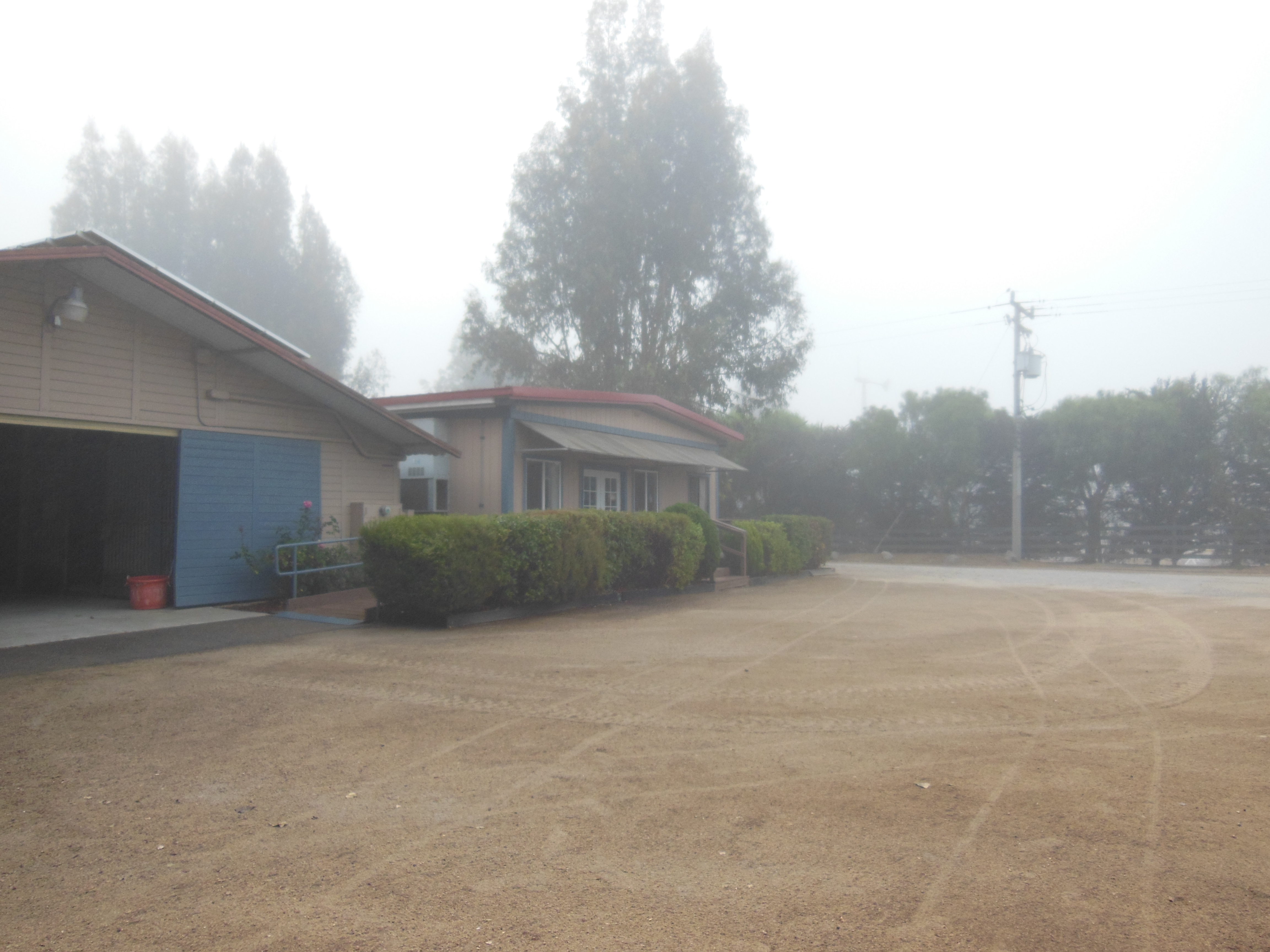 A view of the front office and barn in the fog.